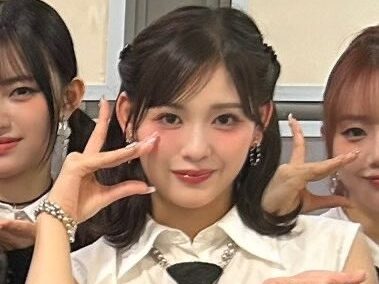 石井蘭(RAN)白シャツに黒いネクタイをした衣装でポーズをとっている